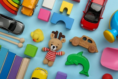 Different children's toys on light blue background, flat lay