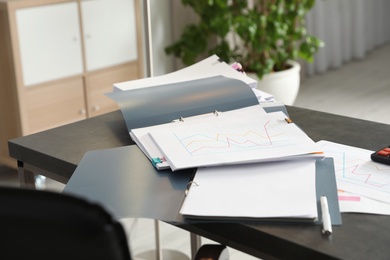 Open folders with documents on office table