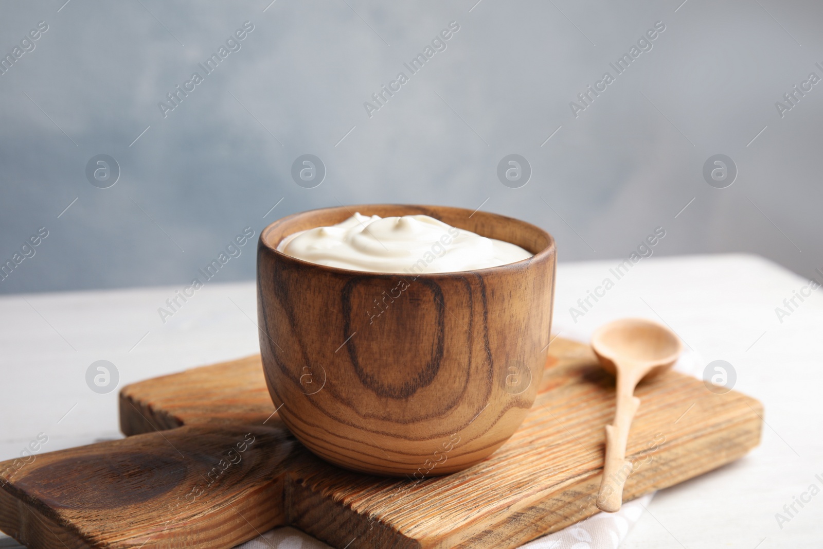 Photo of Wooden bowl with creamy yogurt served on table