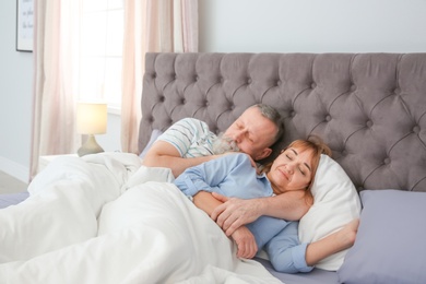 Mature couple together in bed at home