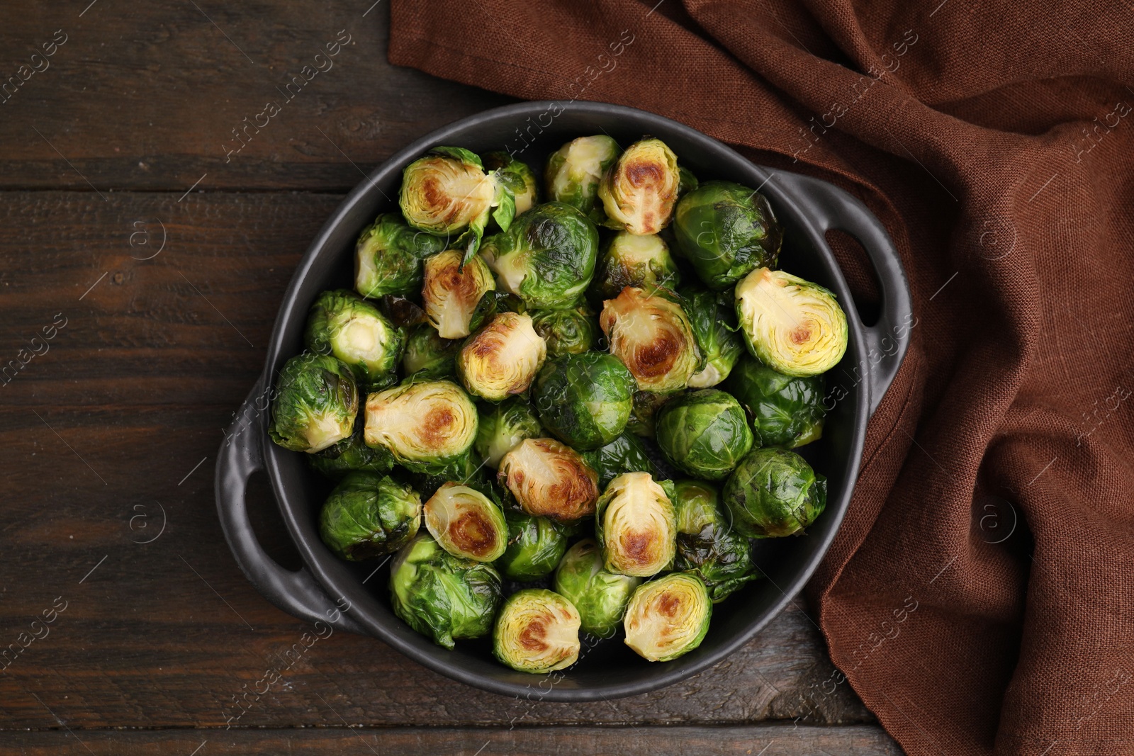 Photo of Delicious roasted Brussels sprouts in baking dish on wooden table, top view