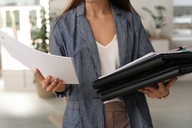 Businesswoman with folders and documents indoors, closeup