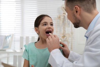 Pediatrician examining little girl in office at hospital