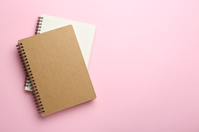 Photo of Two notebooks on pink background, top view. Space for text