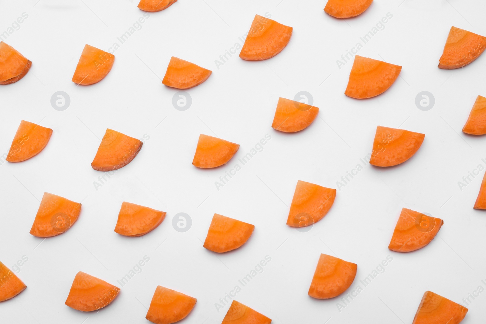 Photo of Slices of fresh raw carrots isolated on white, top view