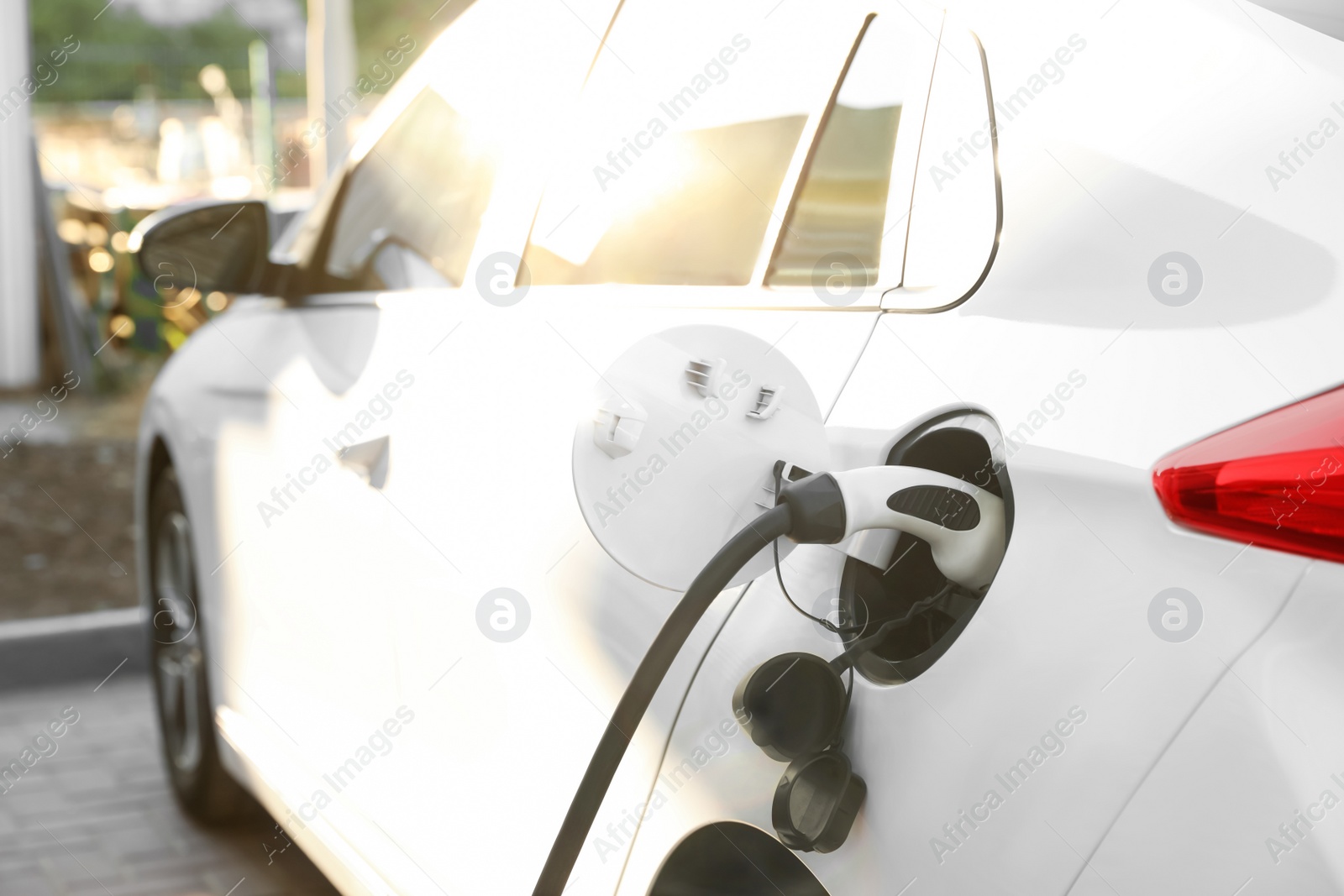 Photo of Charging modern electric car from station outdoors