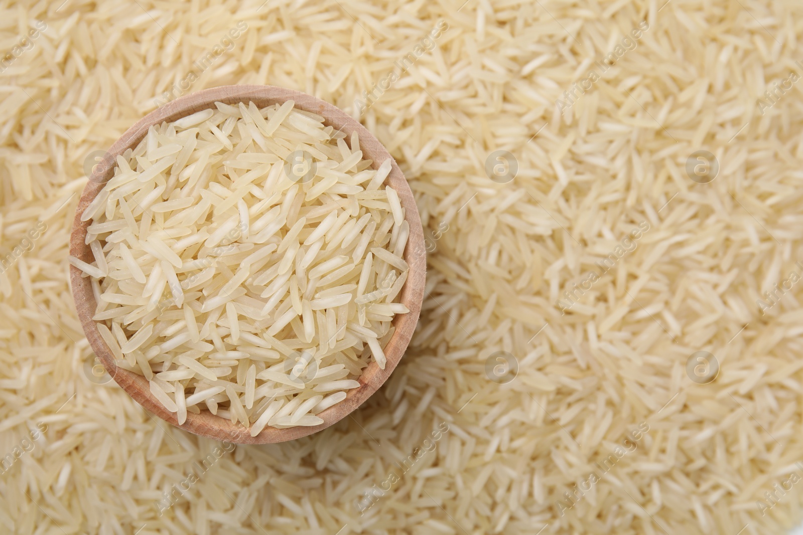 Photo of Bowl and raw rice as background, top view. Space for text