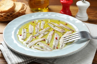 Tasty pickled anchovies with spices on table, closeup