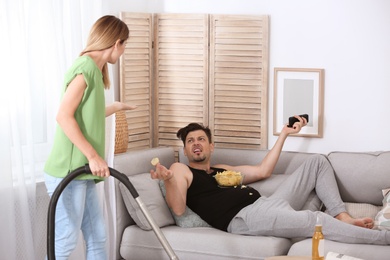 Photo of Lazy husband quarrelling with hardworking wife at home