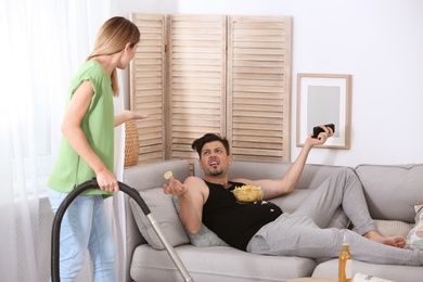 Lazy husband quarrelling with hardworking wife at home