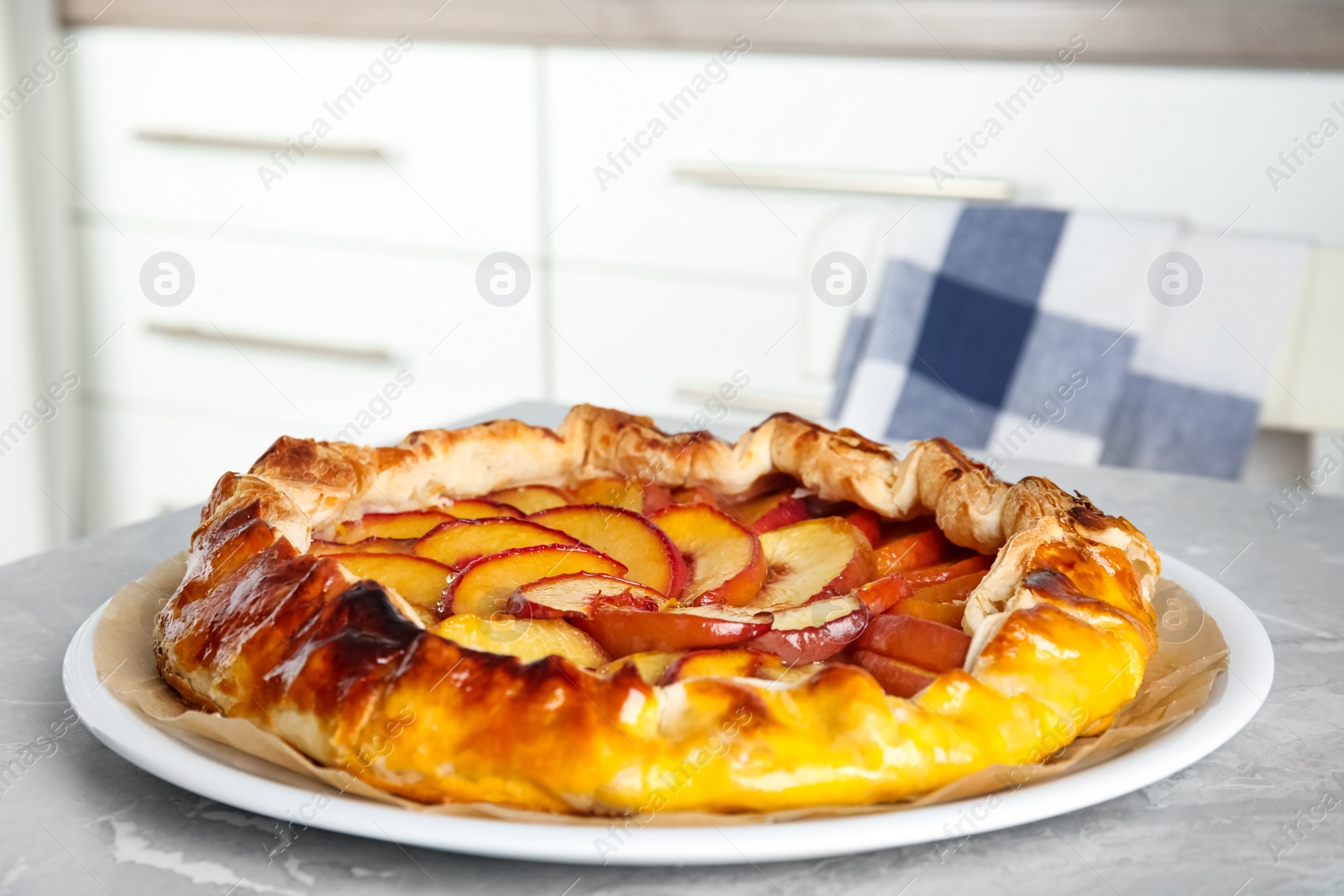 Photo of Delicious fresh peach pie on grey kitchen table, closeup