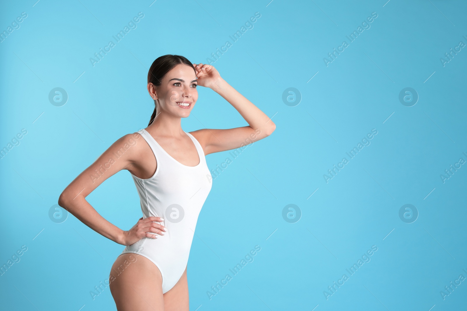 Photo of Portrait of attractive young woman with slim body in swimwear on color background. Space for text