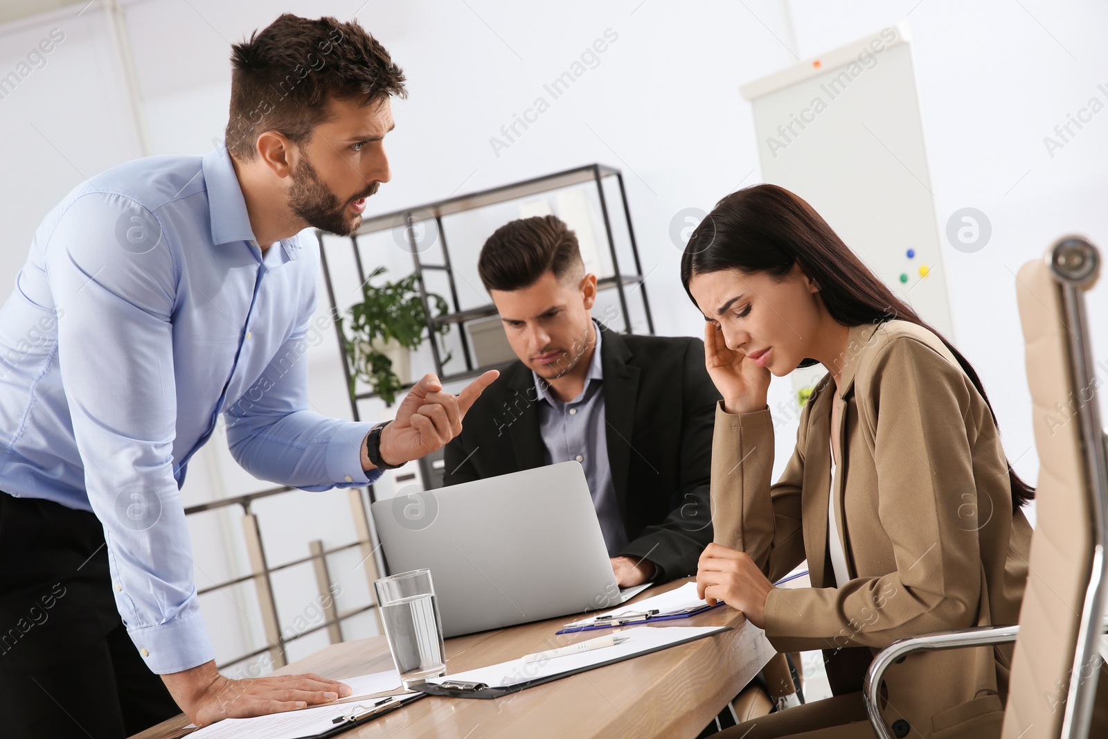 Photo of Boss scolding employee in office. Toxic work environment