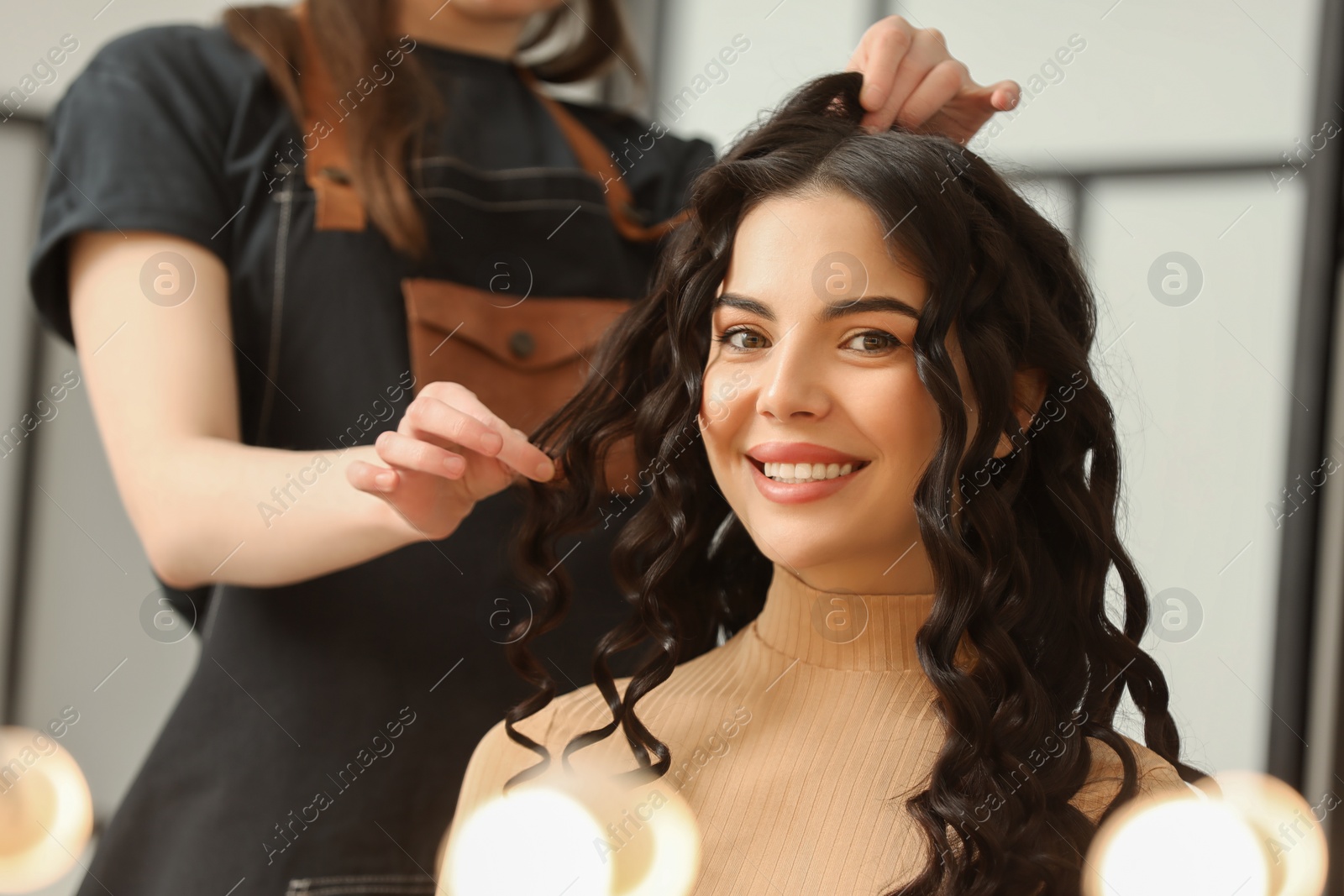 Photo of Hair styling. Professional hairdresser working with smiling client indoors, closeup