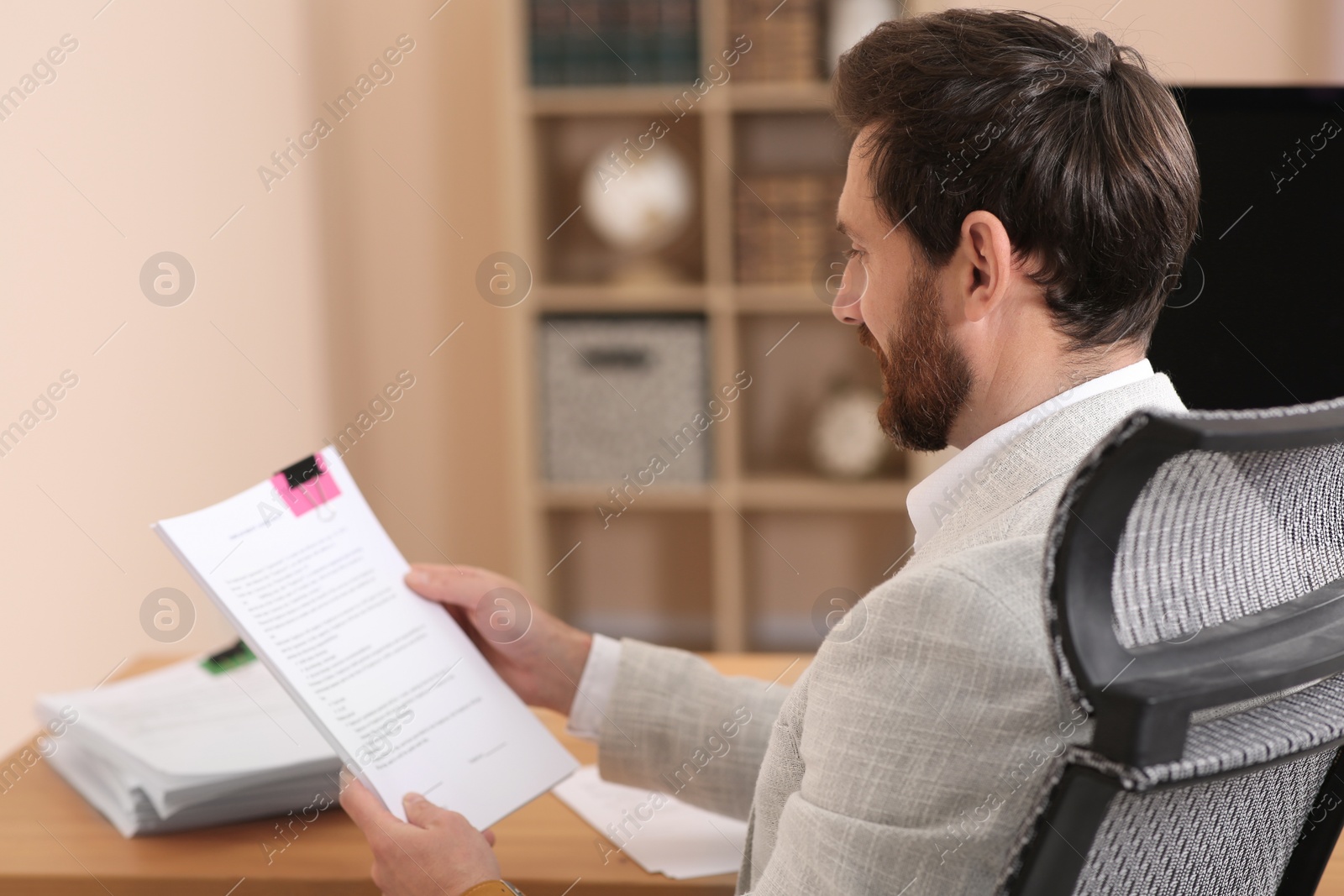 Photo of Businessman working with documents at wooden table in office