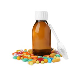 Photo of Bottle of syrup, plastic spoon with pills on white background. Cough and cold medicine