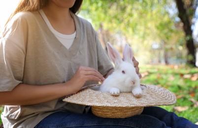 Photo of Woman with cute white rabbit in park, closeup