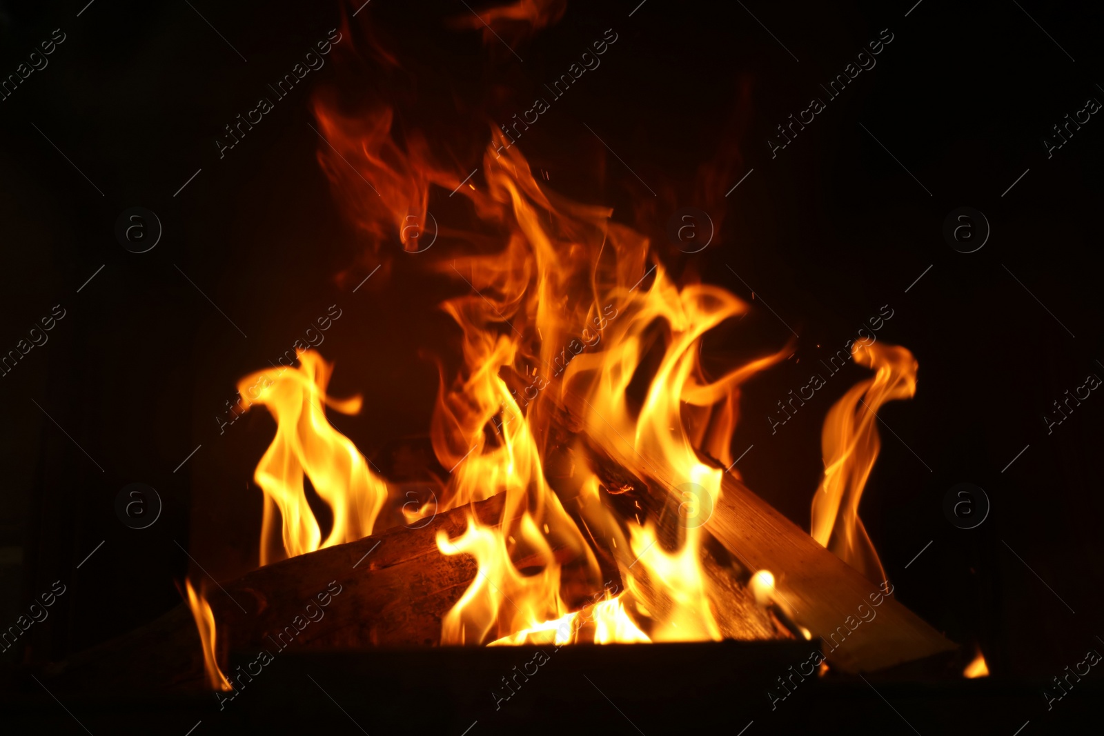 Photo of Fireplace with burning wood, closeup view. Winter vacation