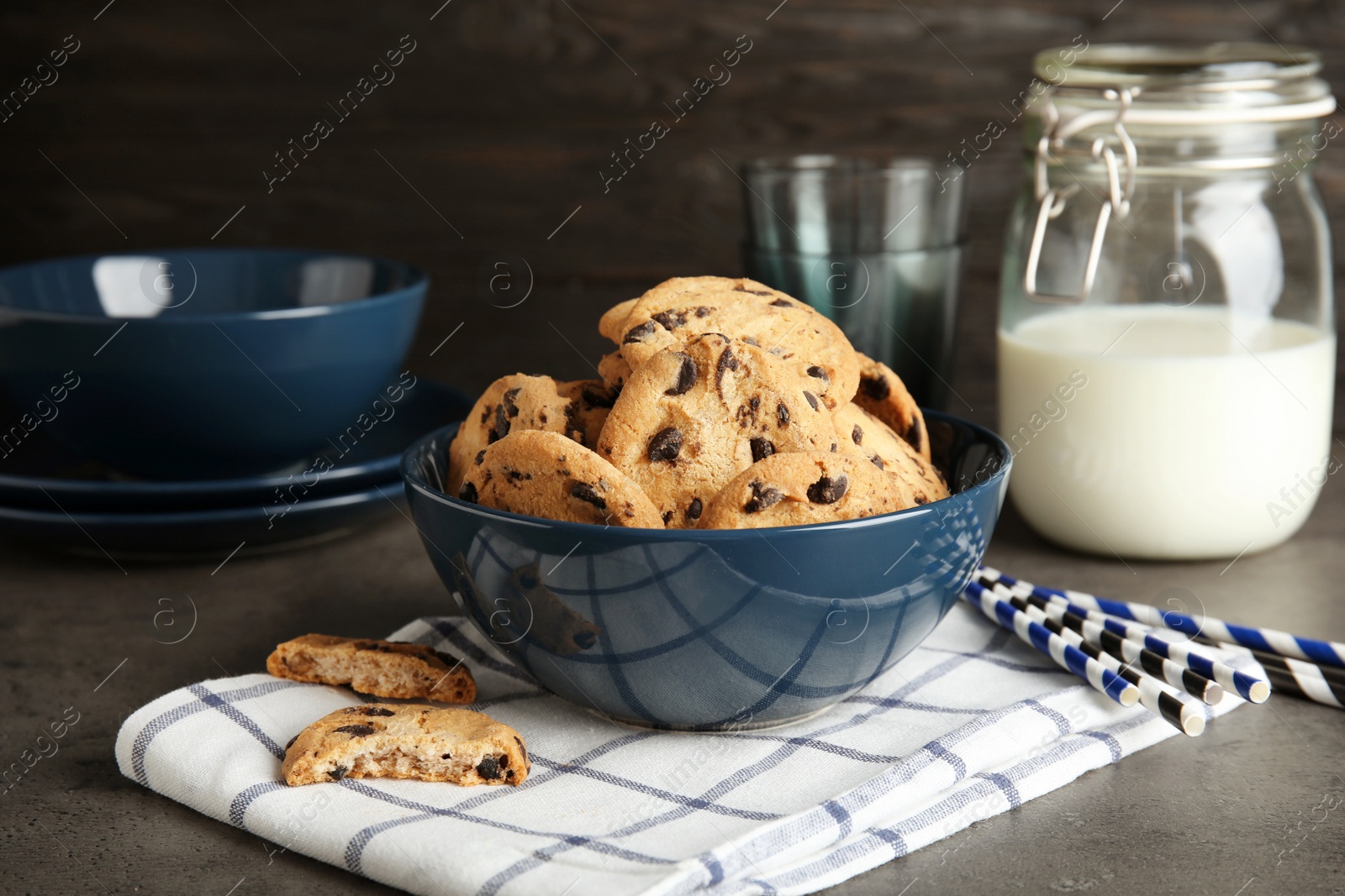 Photo of Bowl with tasty chocolate chip cookies on table