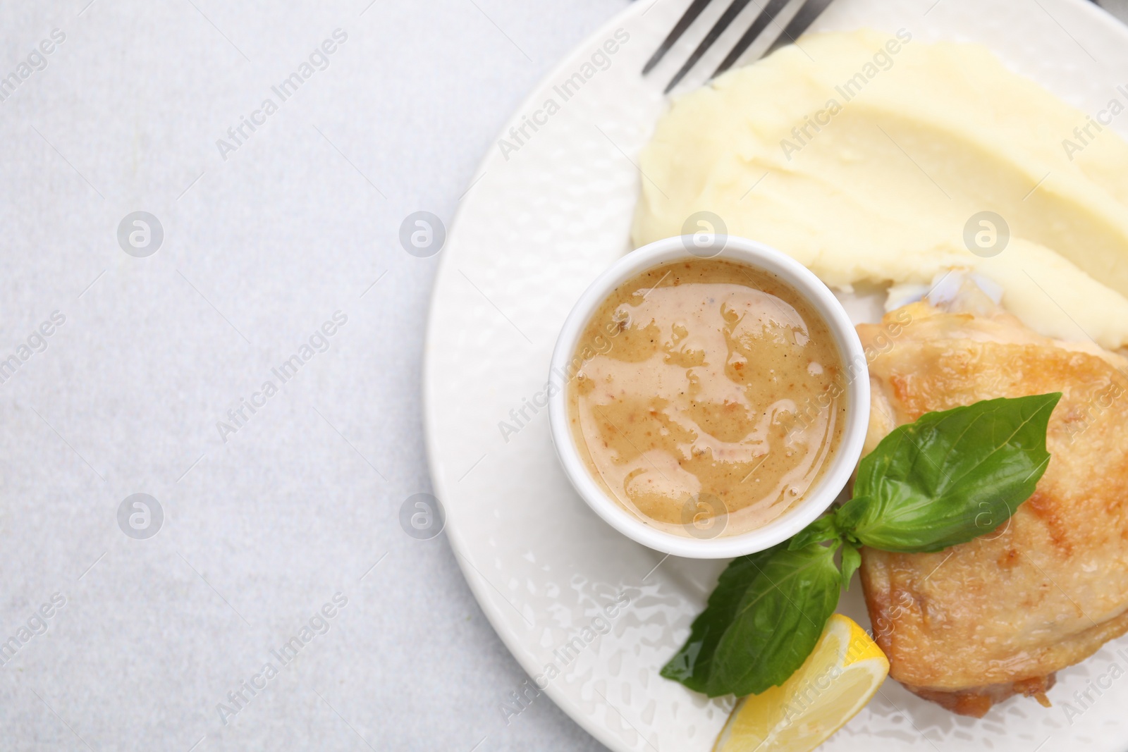 Photo of Delicious turkey gravy served on light grey table, top view. Space for text