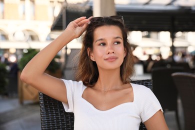 Photo of Portrait of happy young woman in outdoor cafe