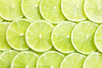 Photo of Fresh sliced ripe limes as background, top view