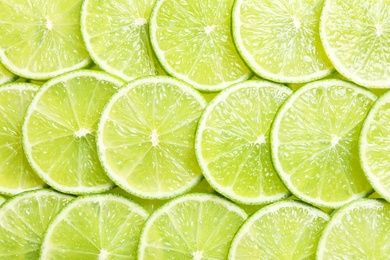 Fresh sliced ripe limes as background, top view