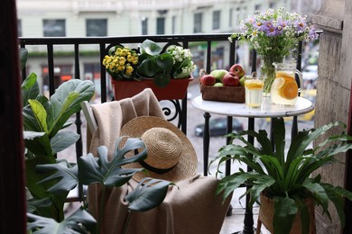 Photo of Relaxing atmosphere. Stylish furniture surrounded by beautiful houseplants on balcony