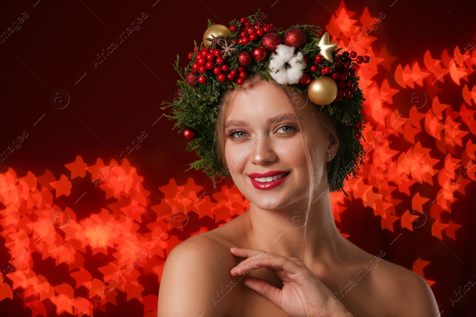 Photo of Beautiful young woman wearing Christmas wreath on blurred background. Bokeh effect