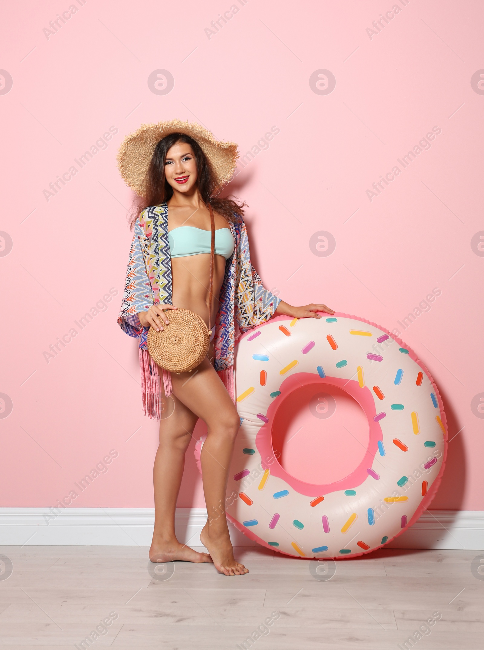 Photo of Beautiful young woman with inflatable ring near color wall