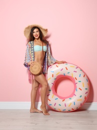 Photo of Beautiful young woman with inflatable ring near color wall