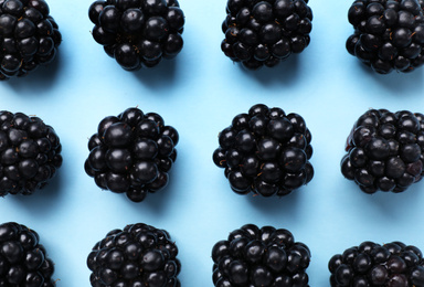 Photo of Tasty ripe blackberries on light blue background, flat lay