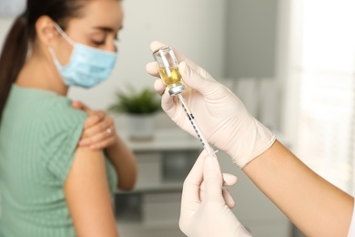 Doctor giving injection to patient in hospital, closeup. Vaccination day