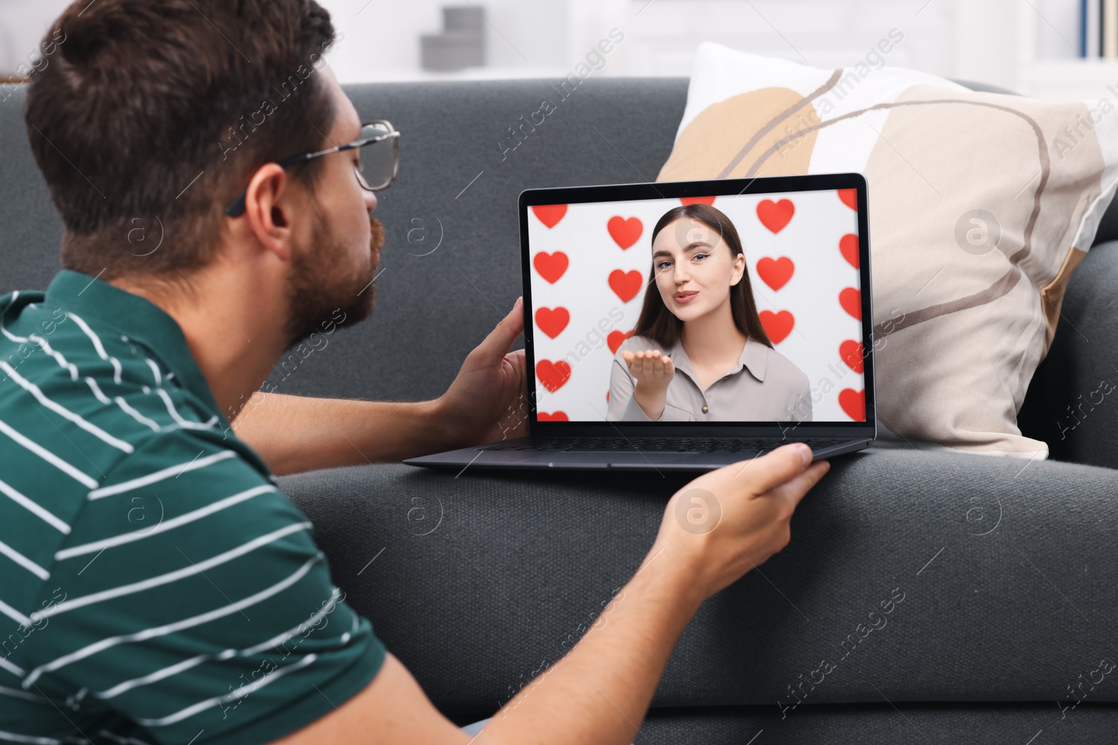 Image of Long distance love. Man having video chat with his girlfriend via laptop at home