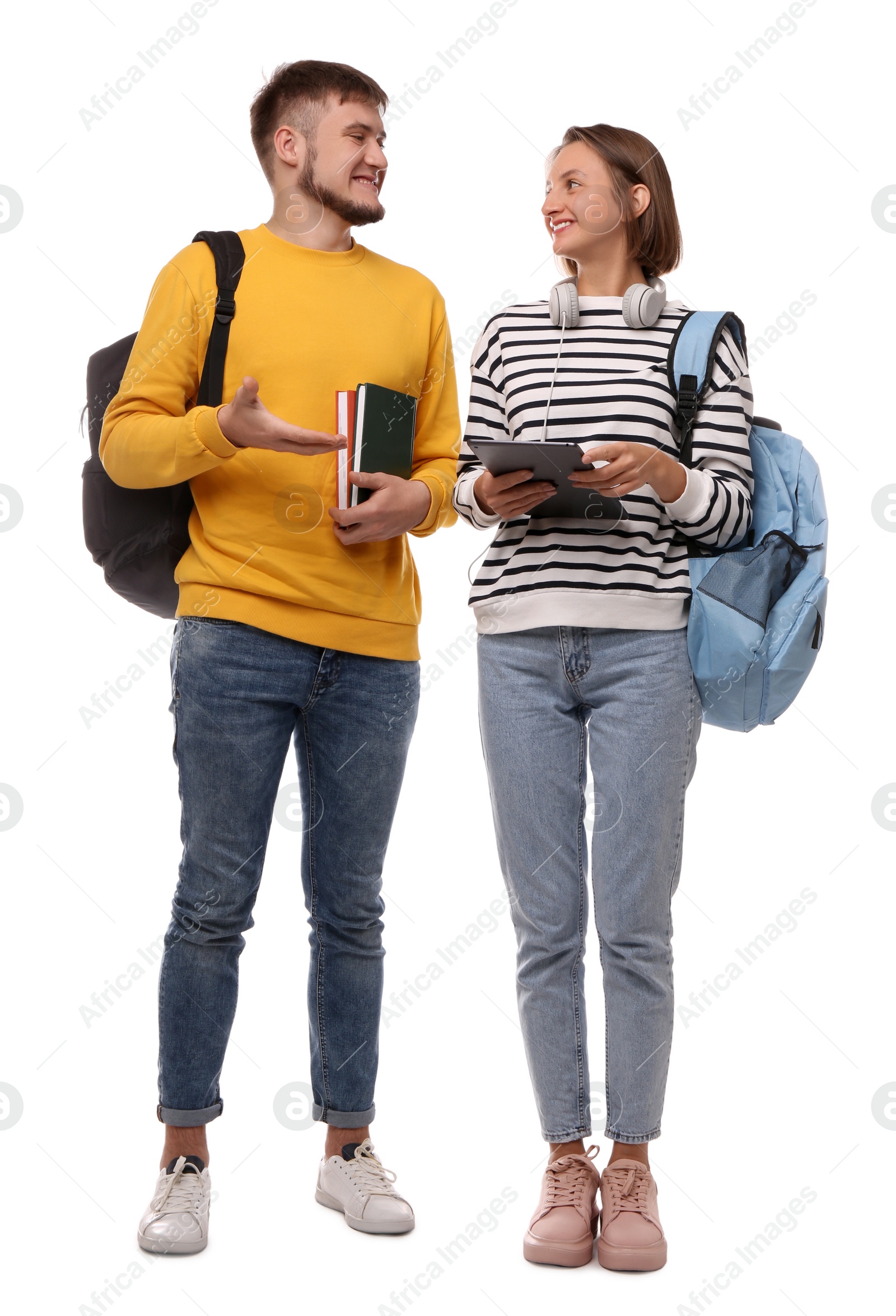 Photo of Young students with backpacks, books and tablet on white background