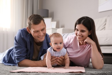 Photo of Happy family with their cute baby on floor at home