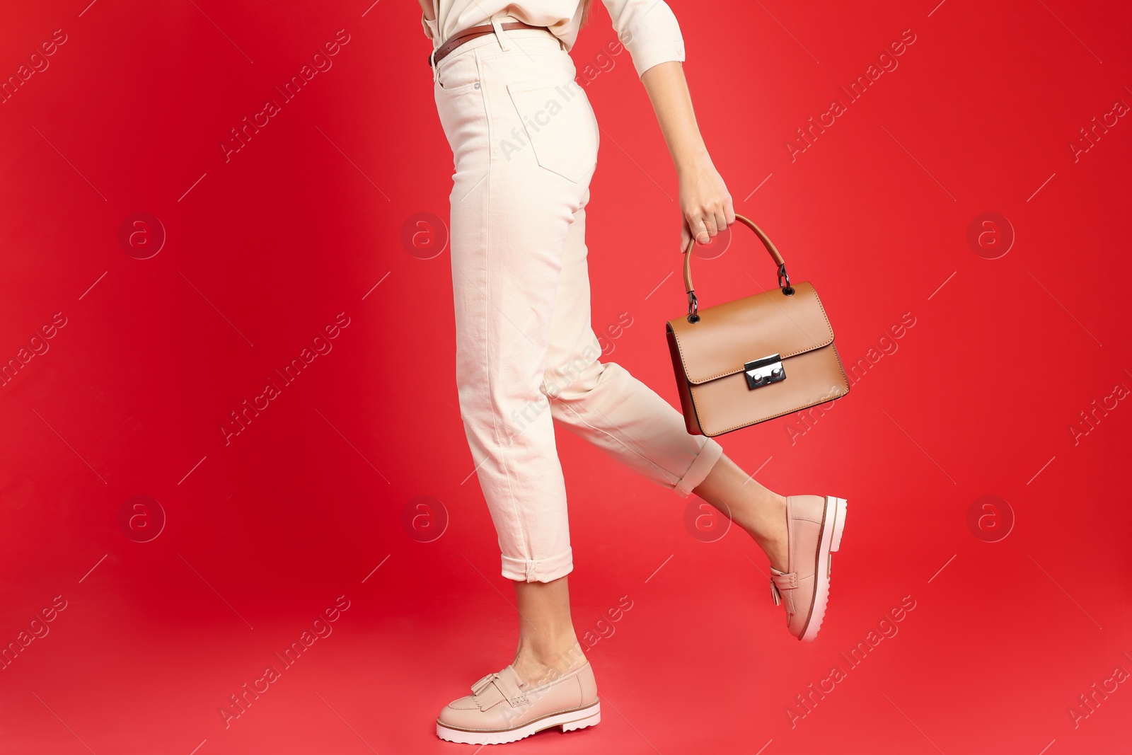 Photo of Young woman with stylish bag on red background, closeup