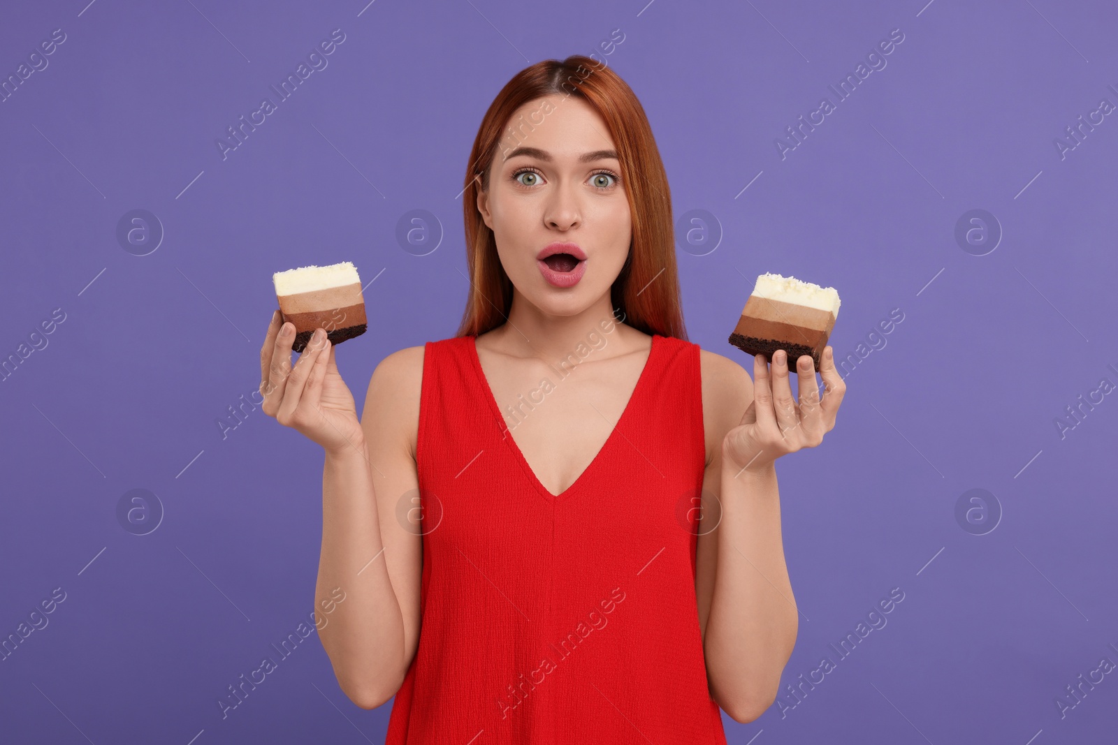 Photo of Emotional young woman with pieces of tasty cake on purple background