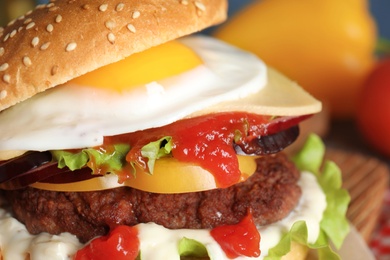 Closeup view of tasty burger with fried egg