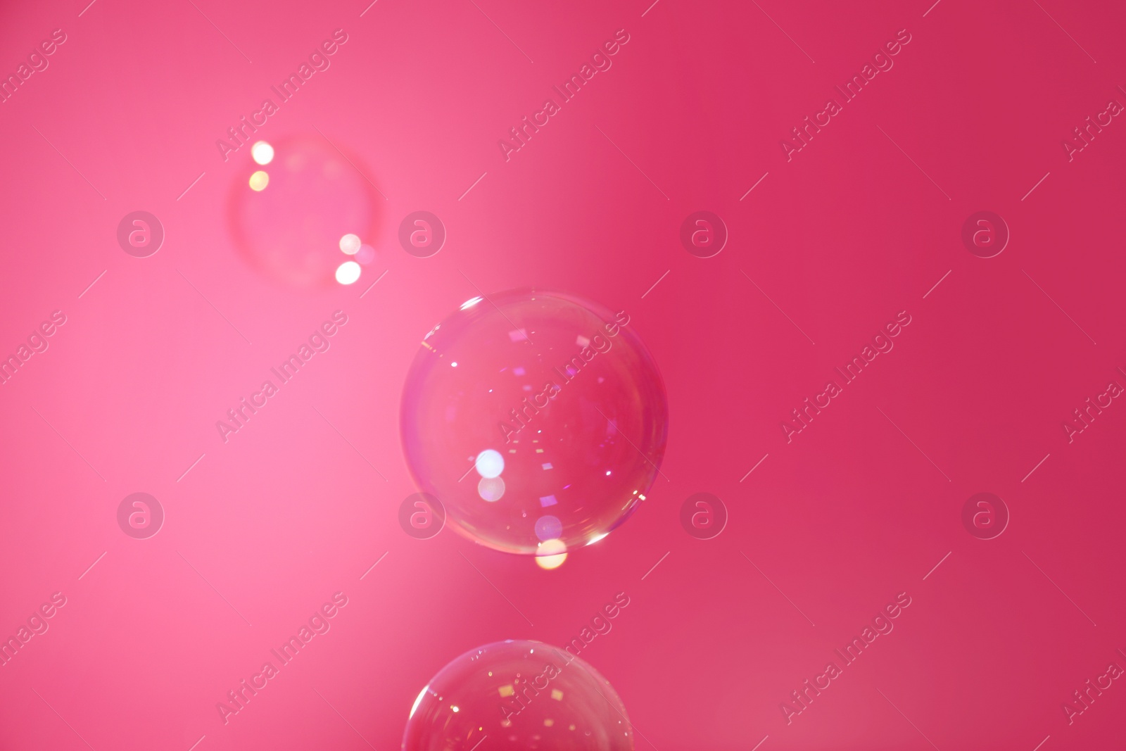 Photo of Beautiful translucent soap bubbles on pink background