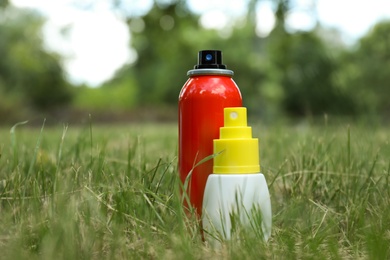 Bottles of insect repellent on green grass