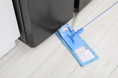 Photo of Cleaning of parquet floor with mop indoors, above view