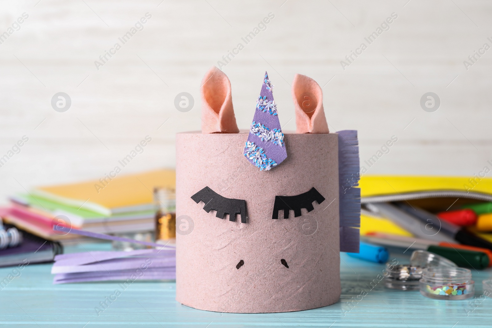 Photo of Toy unicorn made of toilet paper roll on blue wooden table