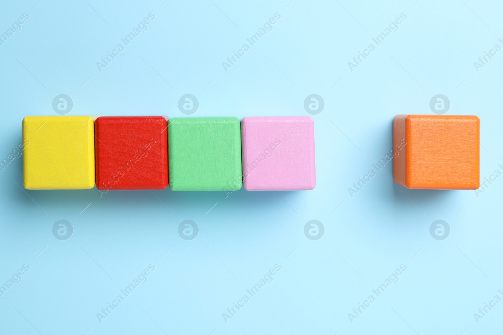 Photo of Flat lay composition with colorful cubes on light blue background. Pareto principle concept