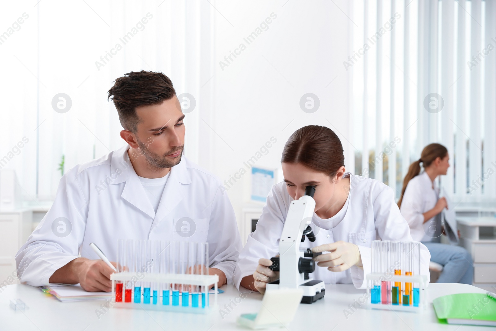 Photo of Medical students with microscope in modern laboratory