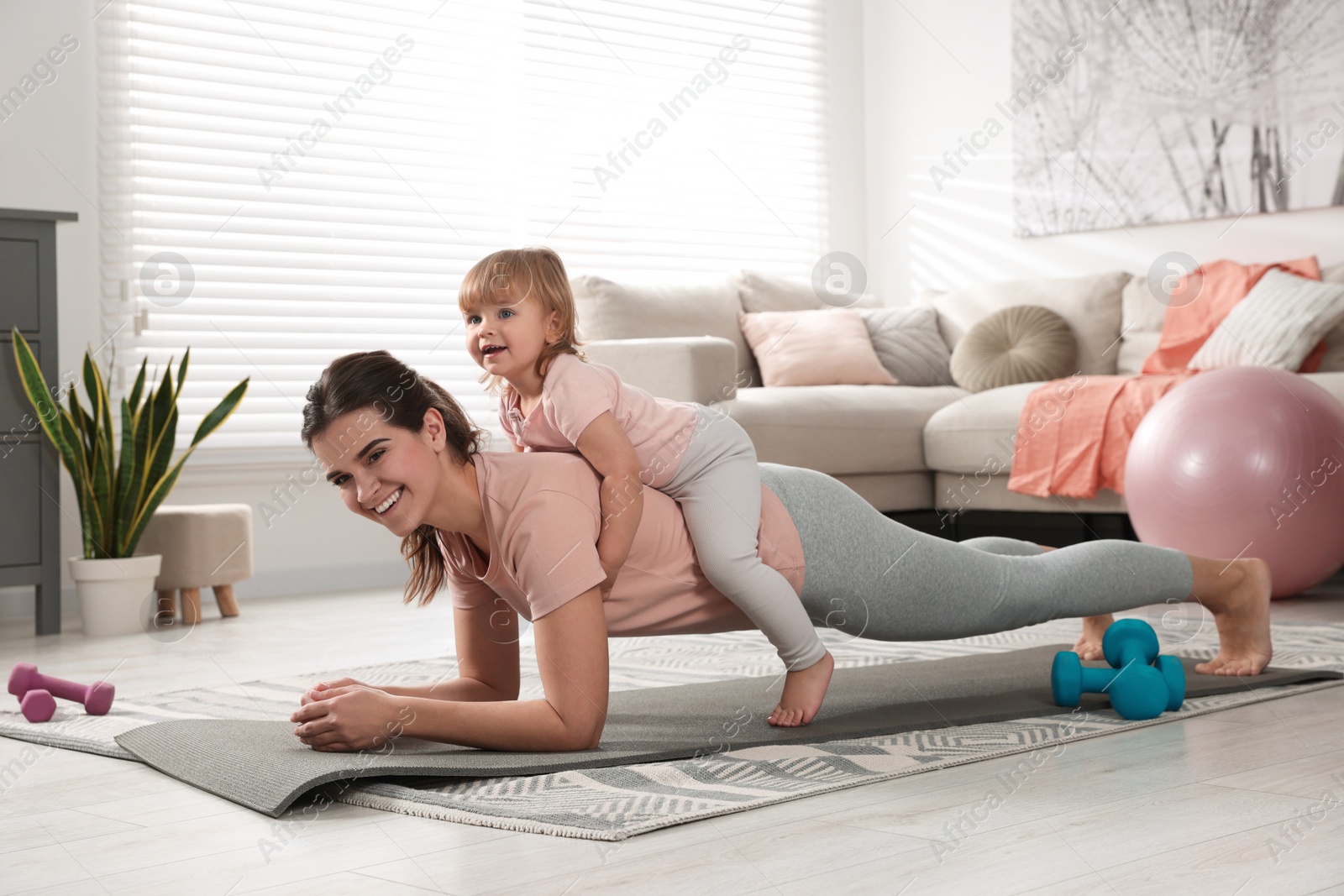 Photo of Mother doing exercise with her daughter at home