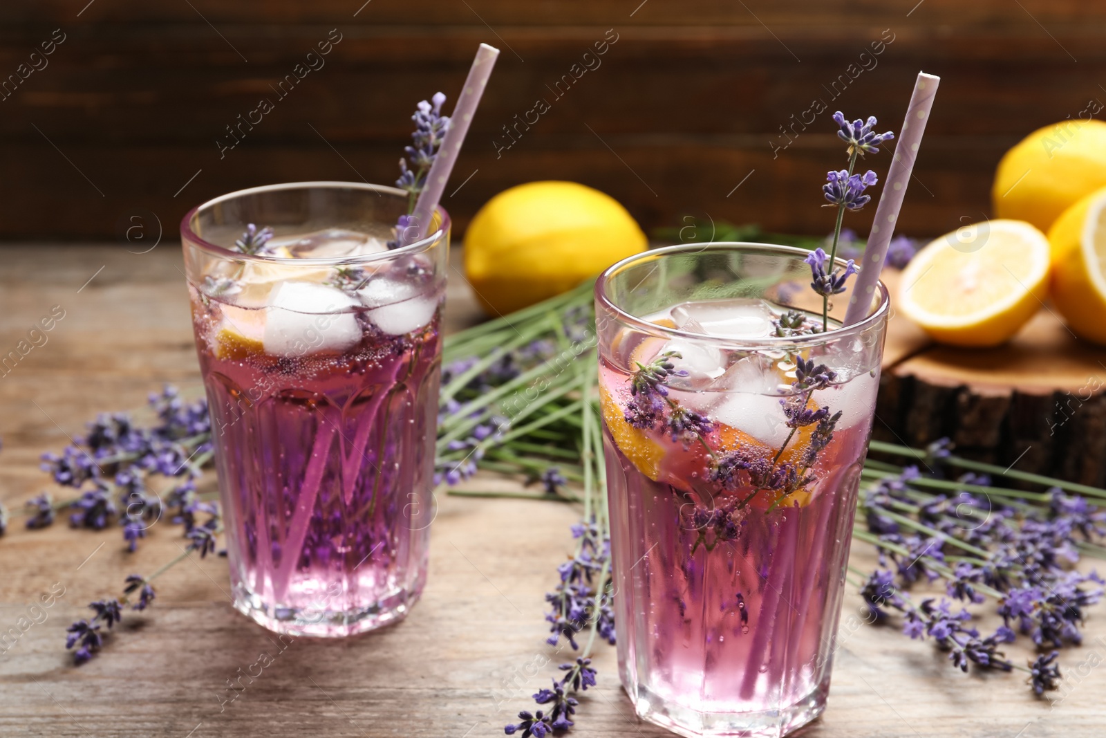 Photo of Fresh delicious lemonade with lavender and straws on wooden table