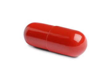 Photo of One red pill on white background. Medicinal treatment