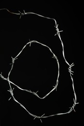 Photo of Shiny metal barbed wire on black background