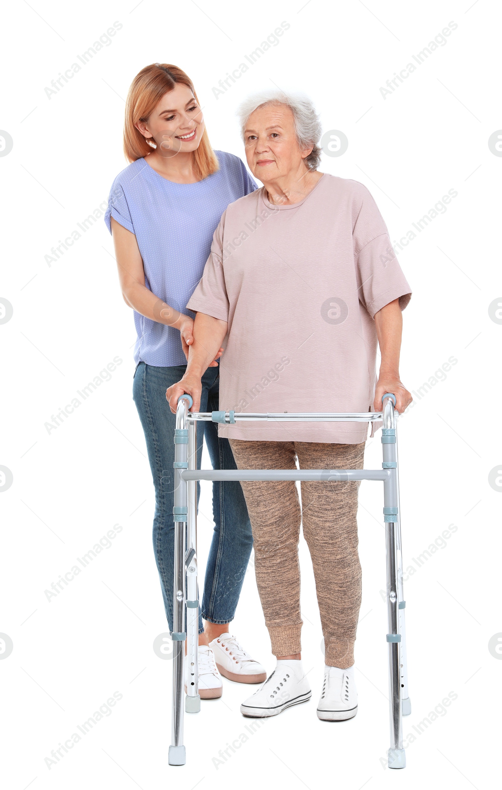 Photo of Caretaker helping elderly woman with walking frame on white background